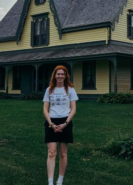 Outdoor photo of podcast guest Heather Harris, poised in the photo in front of a house.