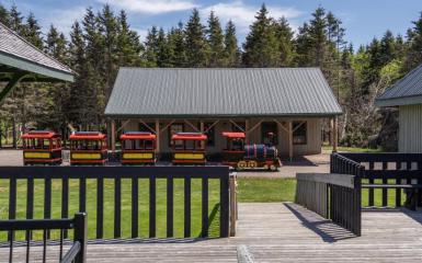 A train and its railcars are queued at its respective station, ready to board passengers.